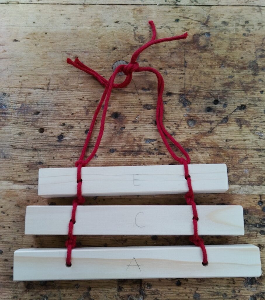 kleine Xylophon: drei Holzstäbe sind wie eine Leiter zusammengebunden